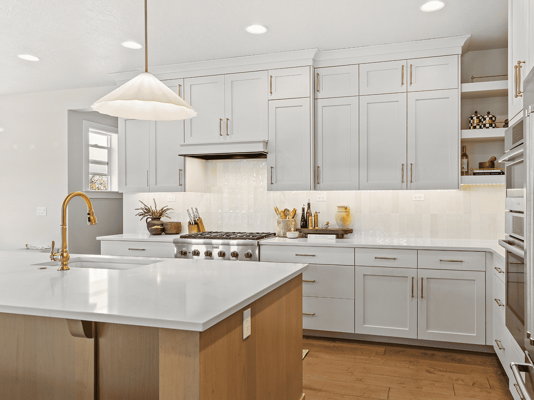 Modern White Kitchen Bright modern kitchen with white cabinets, gold fixtures, and a large island for cooking and dining.