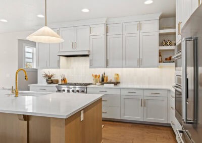 Bright white kitchen with gold accents and island for cooking and entertaining.