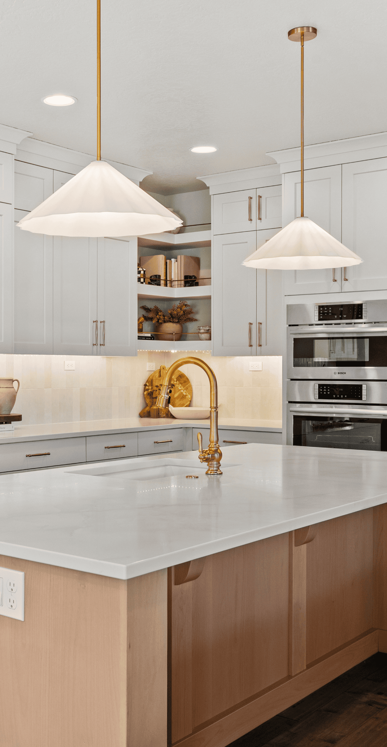 Modern Kitchen Design Bright modern kitchen with white cabinets, gold fixtures, and a marble island.
