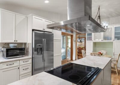 Contemporary kitchen with stainless steel appliances and white cabinetry.