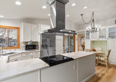 Spacious modern kitchen with white cabinets, stainless steel appliances, and a central island.