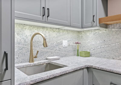 Contemporary kitchen with granite countertops and gray cabinets.