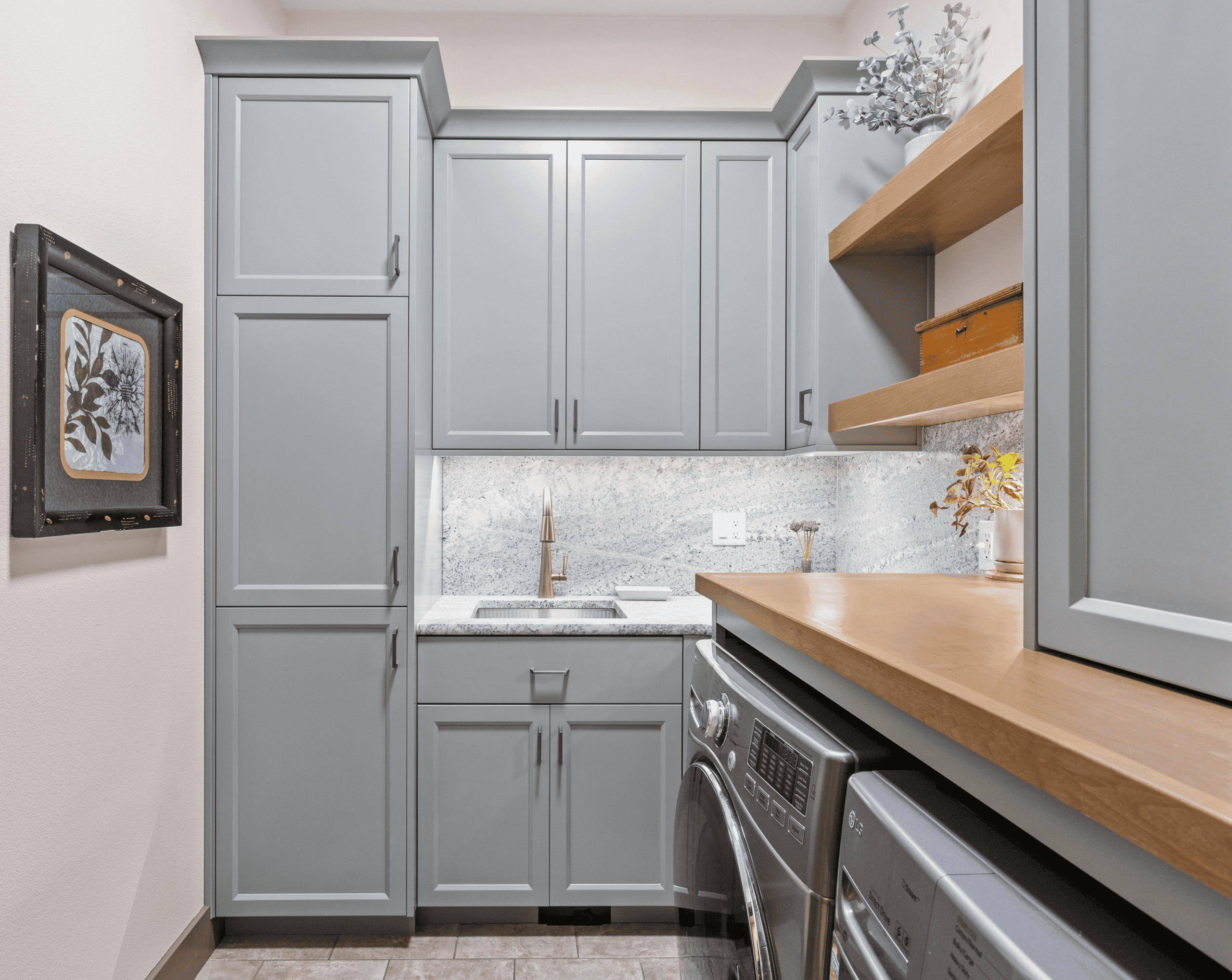 Light blue kitchen cabinets with wooden shelves and washer-dryer units.
