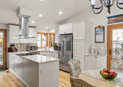 Bright modern kitchen with white cabinets, stainless steel appliances, and a central island.