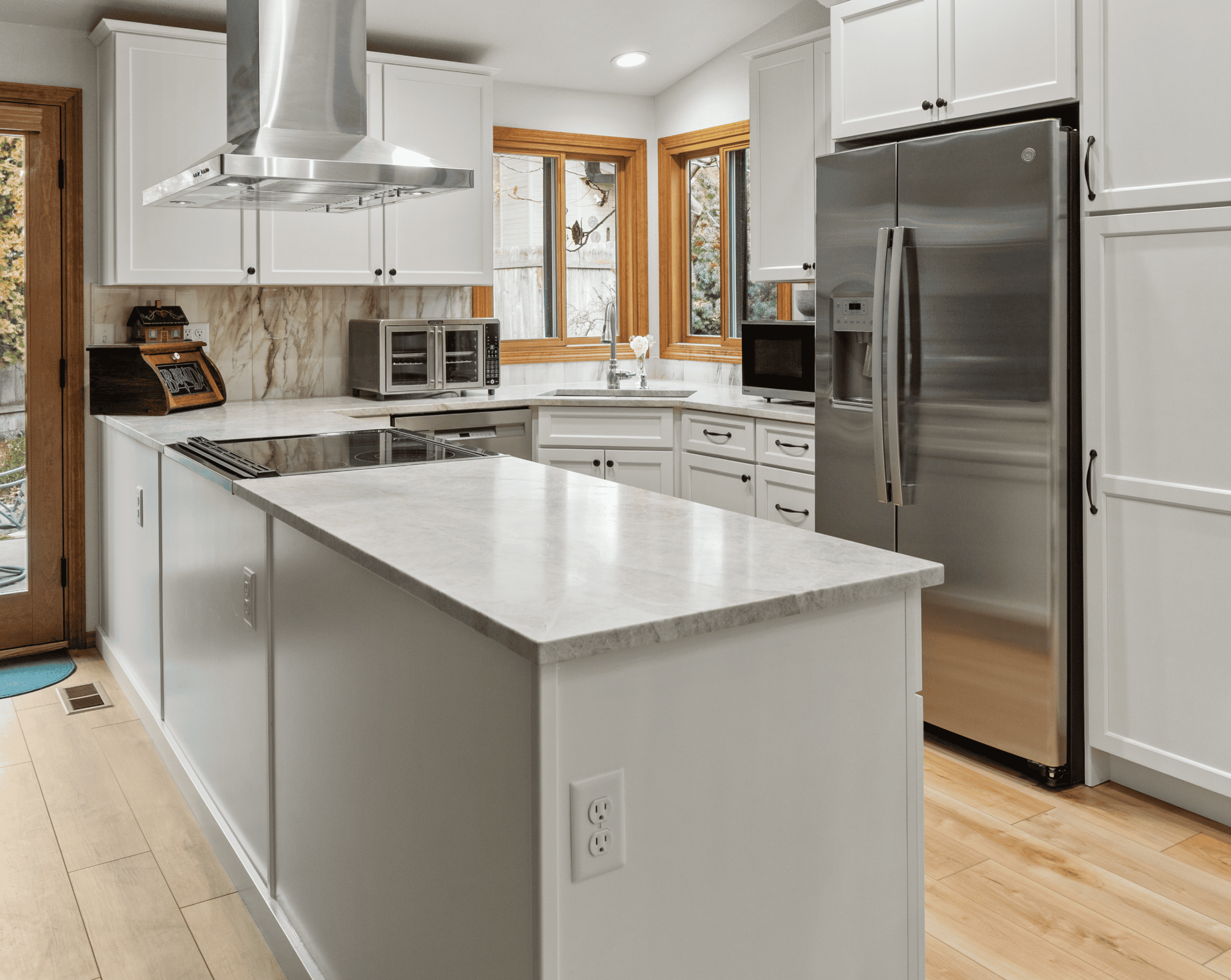 Modern Kitchen Design Bright modern kitchen with white cabinets, stainless steel appliances, and a marble island.