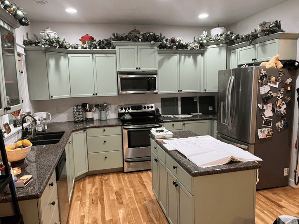 Cozy Kitchen with Holiday Bright kitchen with mint green cabinets, stainless steel appliances, and holiday decorations on top.