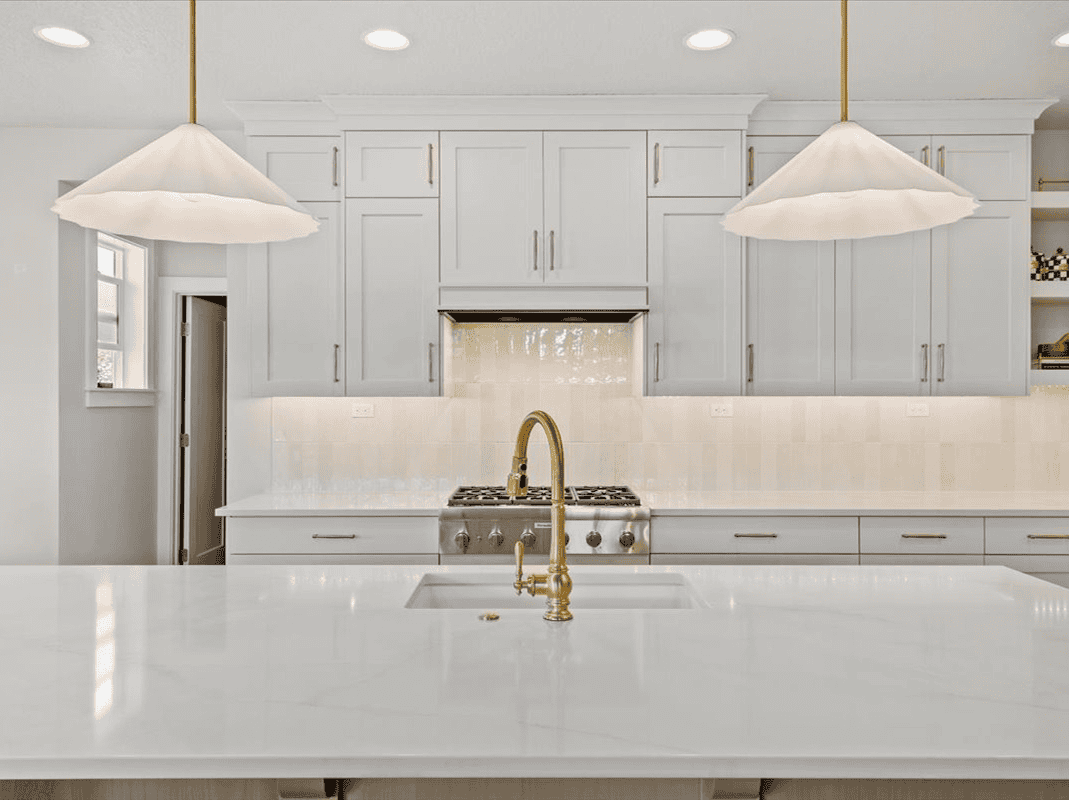 Modern Kitchen Design Bright modern kitchen with white cabinets, gold fixtures, and a marble island.