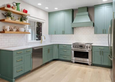 Contemporary kitchen with teal cabinets, white subway tile backsplash, and stainless steel stove.