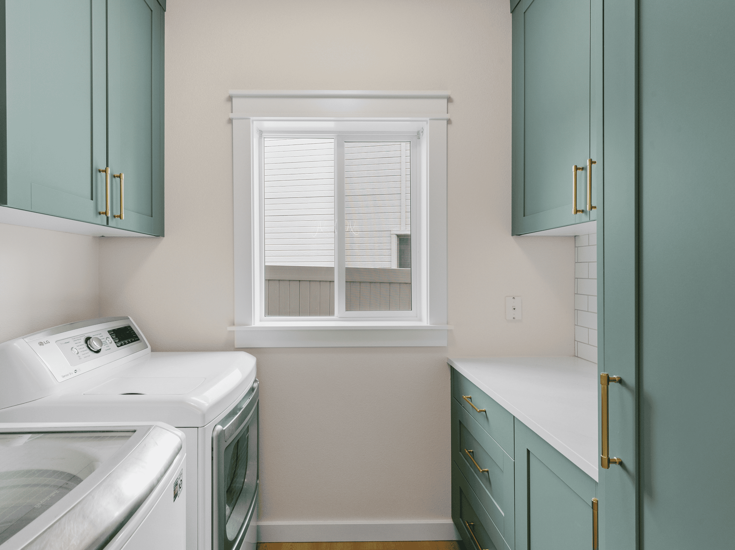 Laundry Room with Storage Bright laundry room with teal cabinets, white washer, and a window for natural light.