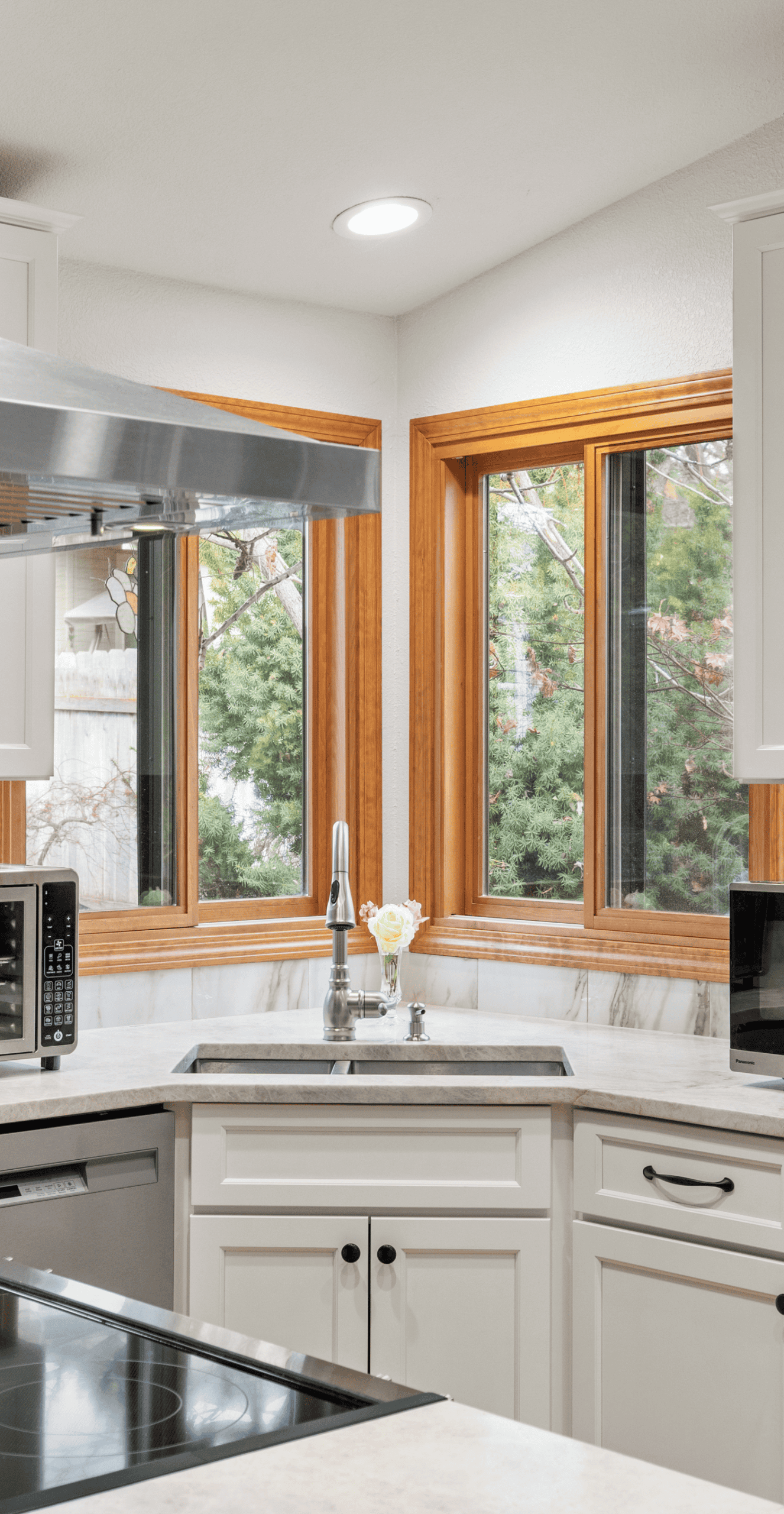 Cozy Kitchen with Natural Bright kitchen with large windows, white cabinets, and marble countertops.