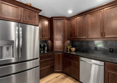 Contemporary kitchen with dark wood cabinets and stainless steel appliances.
