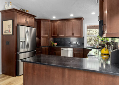 Spacious kitchen with dark granite countertops and wooden cabinets.