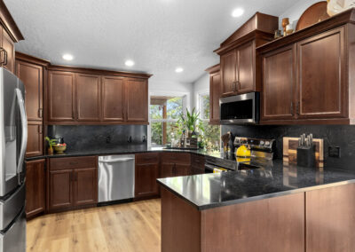 Beautiful modern kitchen with dark wood cabinets and black countertops.